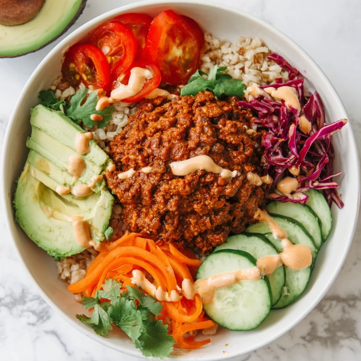 Colorful plant-based meat bowl topped with fresh veggies and zesty lime wedges.  