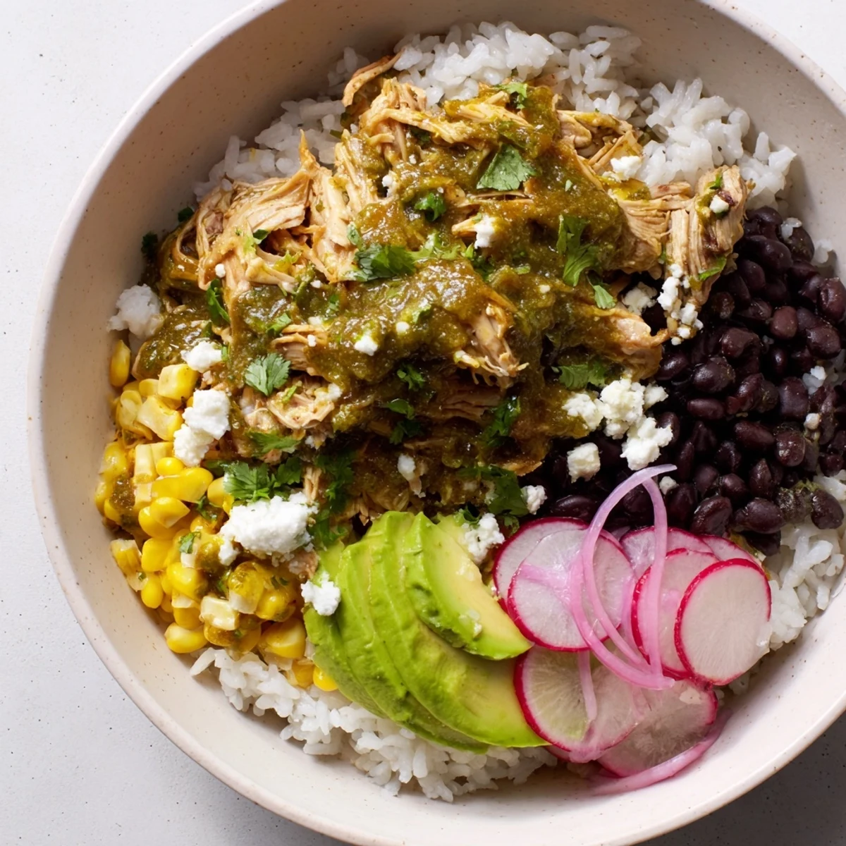 Savory close-up of Green Enchiladas Rice Bowl, showcasing fluffy rice topped with flavorful chicken and fresh cilantro.