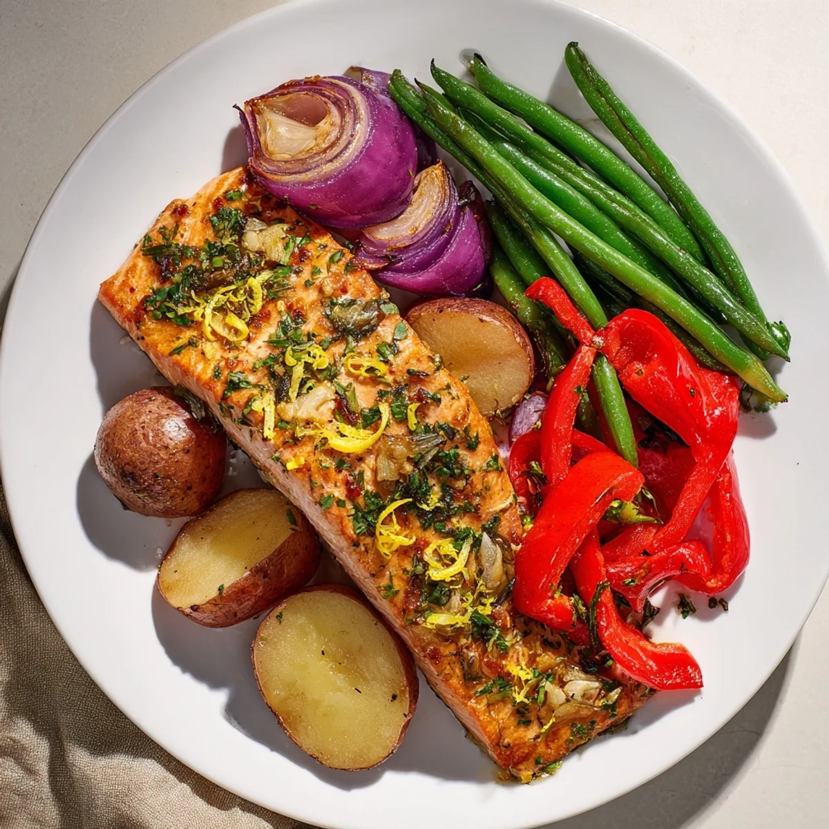 Golden-brown Lemon Herb Salmon & Potato Sheet Pan with roasted vegetables, perfect for dinner.