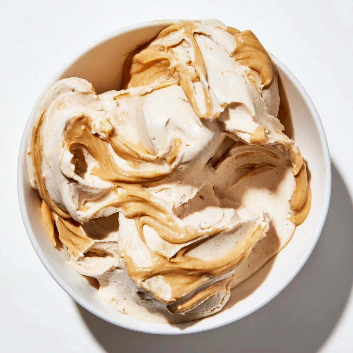 Rich and decadent Peanut Butter Banana Ice Cream swirled in a bowl, a healthy dessert option.