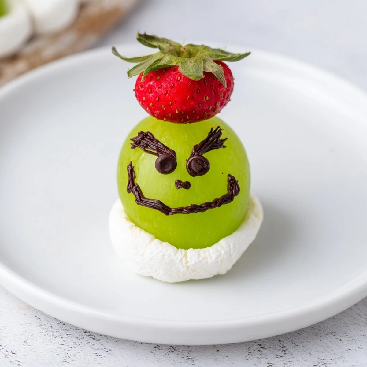 Easy Grinch Snack recipe featuring juicy green grapes, fluffy marshmallows, and edible chocolate faces.