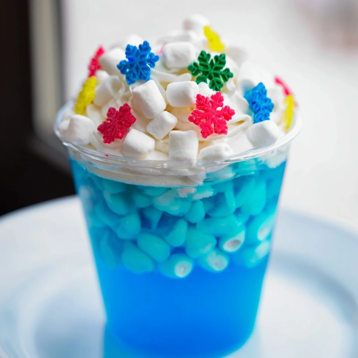 Vibrant blue Snow Globe Jello Cups, a fun dessert loaded with marshmallows and sprinkles for kids.