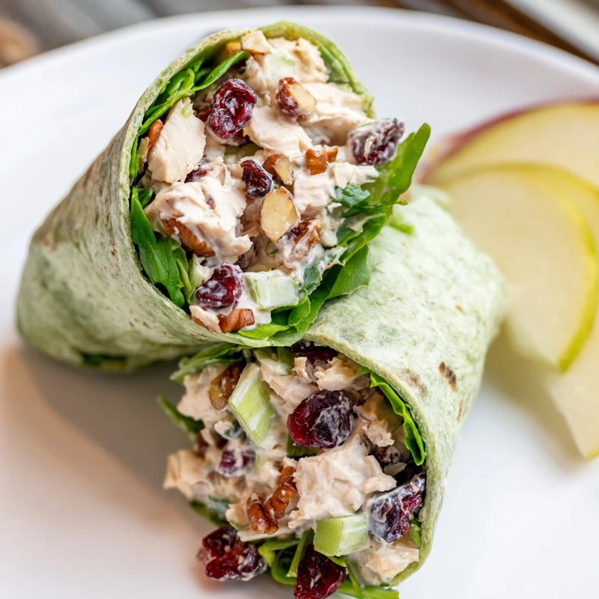 A delicious close-up of a Cranberry Pecan Chicken Salad Christmas Wrap, showcasing fresh greens and colorful ingredients.