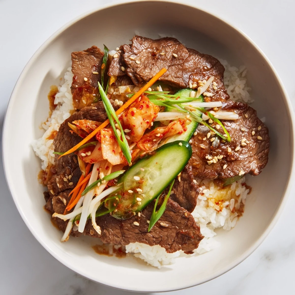 A steaming Bulgogi Beef Bowl: tender marinated beef atop fluffy rice, garnished with fresh veggies.