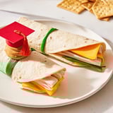 Delicious Graduation Cap Diploma Snack Wraps ready to serve, with rolled tortillas and mini truffle hats.