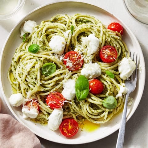 Close-up of Pesto Pasta with Burrata, showing the creamy cheese melting into al dente noodles.