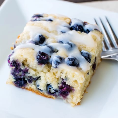 A delicious slice of Blueberry Pancake Soda Sheet Cake drizzled with icing.  