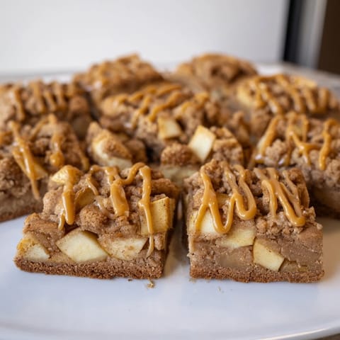 Warm layers of caramel and cinnamon apples in spiced cookie bars, a cozy treat.  
