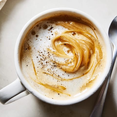 Savory Onion Latte featuring caramelized onion puree and espresso, served steaming hot.  