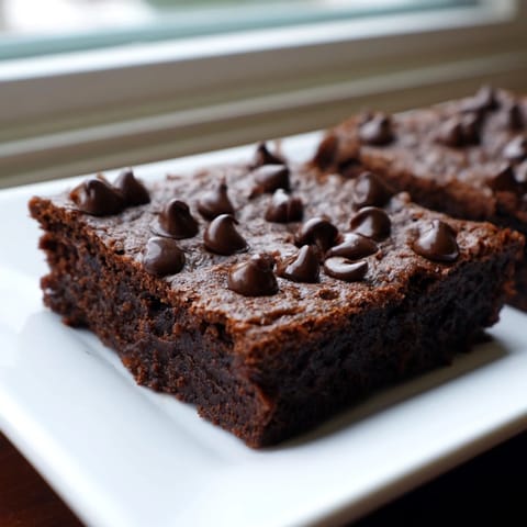Moist, dark Greek yogurt brownies, perfectly cut and ready to enjoy with a bit of extra dark chocolate.
