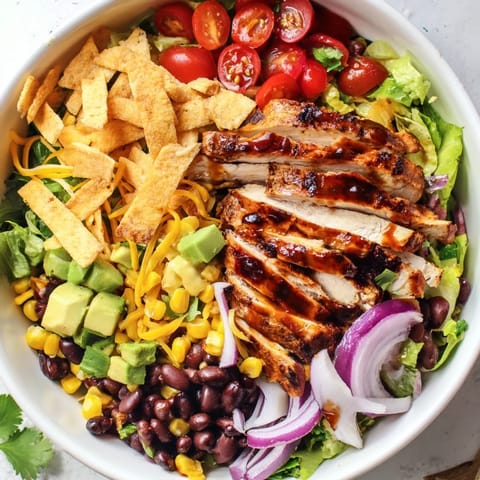 Zesty honey lime chicken taco salad features juicy grilled chicken, sweet corn, and crunchy tortilla strips.  