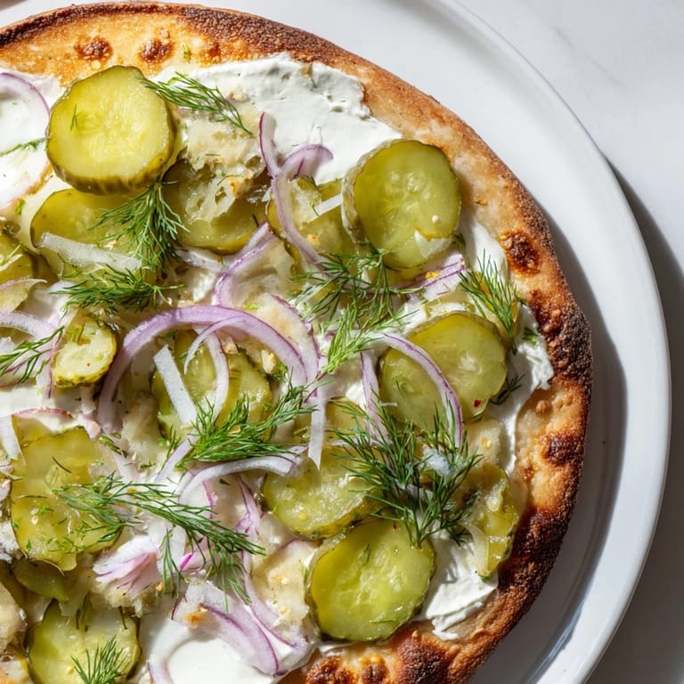 Deliciously adventurous Pickle Pizza, featuring melted mozzarella and zesty pickles on crust.