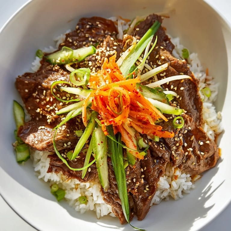 Savory Bulgogi Beef Bowl with thinly sliced beef, vibrant stir-fried vegetables, and sesame seeds; a delightful meal.