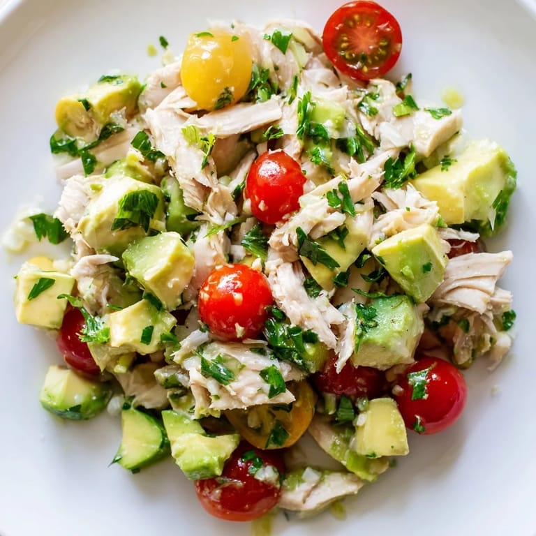 Healthy Avocado Chicken Salad served in a bright bowl, featuring juicy tomatoes and herbs, perfect for a quick, gluten-free lunch.