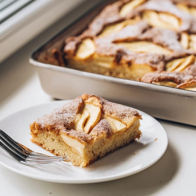Golden Baked Apple Cake with moist, spiced apple layers, perfect for a cozy brunch with a dollop of crème fraîche.