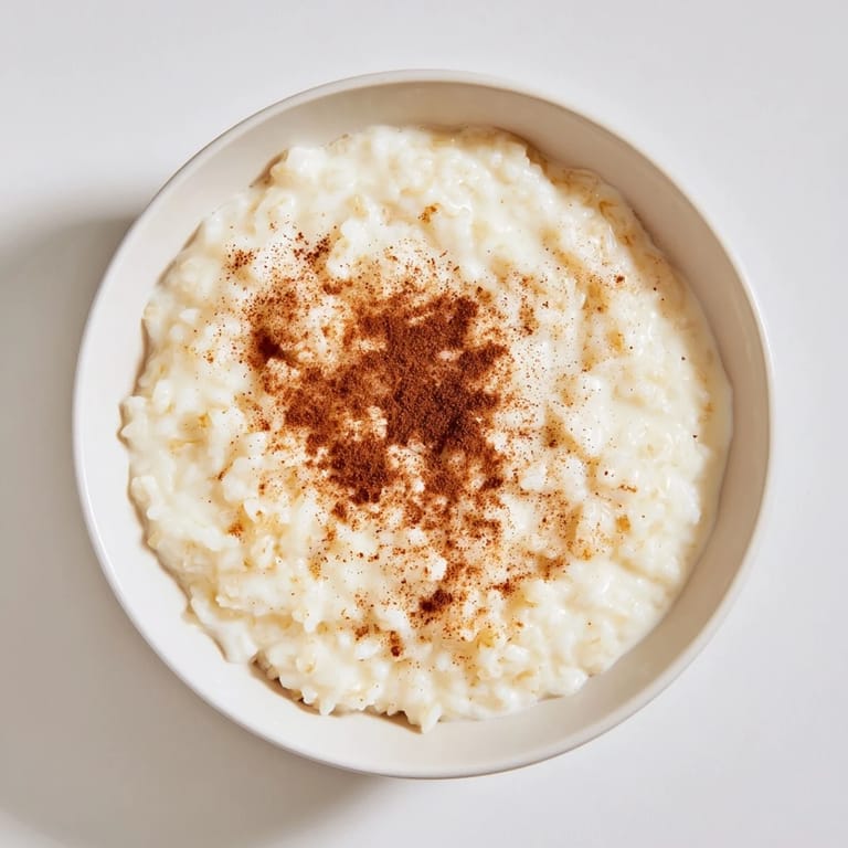 Delicious, thick Rice Pudding with leftover rice, garnished with a sprinkle of cinnamon, perfect for dessert.