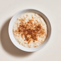 A warm bowl of creamy Rice Pudding with leftover rice, dusted with sweet cinnamon and ready to serve.